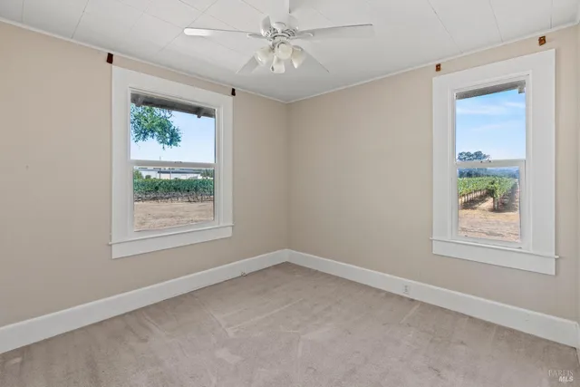 an empty room with a window and a ceiling fan