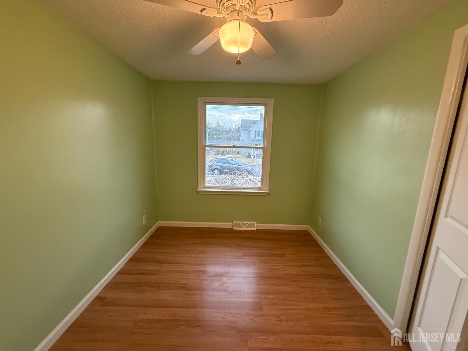 109 John Street Helmetta, NJ 08828 - Photo 8 of 18 an empty room with wooden floor and windows