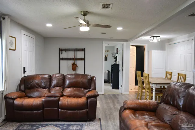 a living room with furniture a ceiling fan and a rug