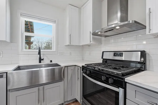 a kitchen with kitchen island granite countertop stainless steel appliances a sink stove and cabinets