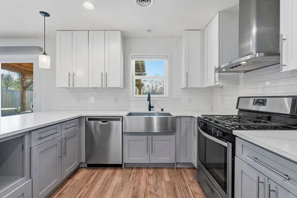 a kitchen with stainless steel appliances granite countertop a sink stove and cabinets