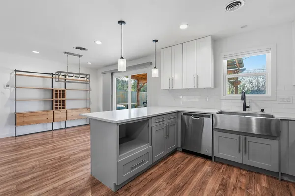 a kitchen with a sink cabinets and wooden floor