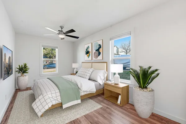 a bedroom with a large bed a couch and potted plant