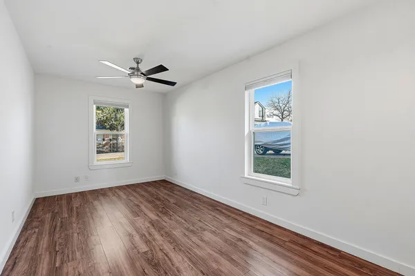 a view of a big room with wooden floor and windows