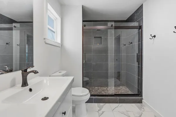 a bathroom with a shower a toilet and a sink