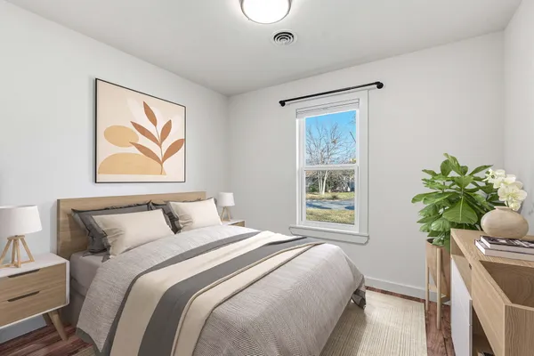 a bedroom with a bed potted plant and a window