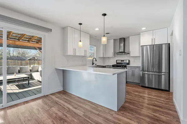 a kitchen with kitchen island a counter top space a refrigerator a sink and a large window