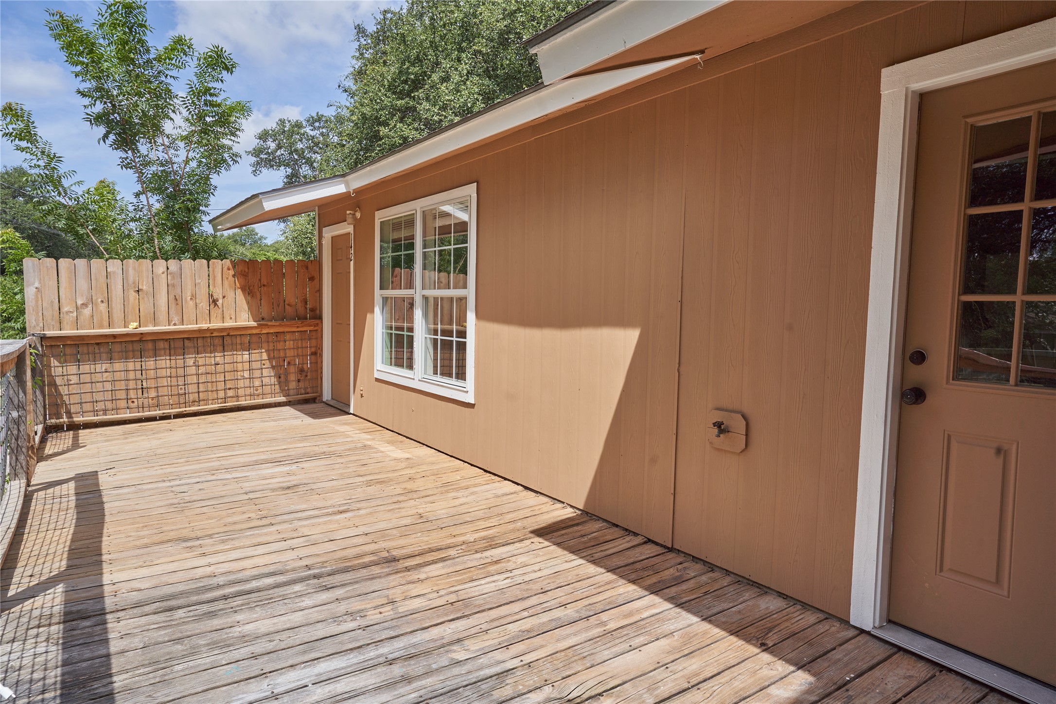 23393 Nameless Road, Unit 142 Leander, TX 78641 - Photo 12 of 15 A spacious wooden deck extends from the exterior, offering an ideal spot for outdoor enjoyment.