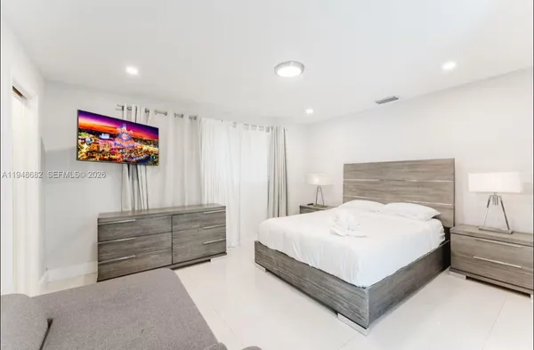 a bedroom with a bed and a flat screen tv