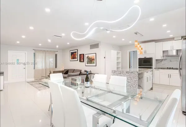 a living room with kitchen island furniture and a view of kitchen
