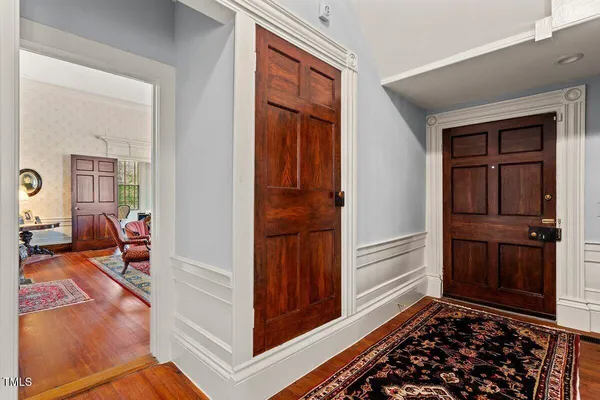 a kitchen with stainless steel appliances granite countertop a refrigerator a stove top oven a sink dishwasher and white cabinets with wooden floor