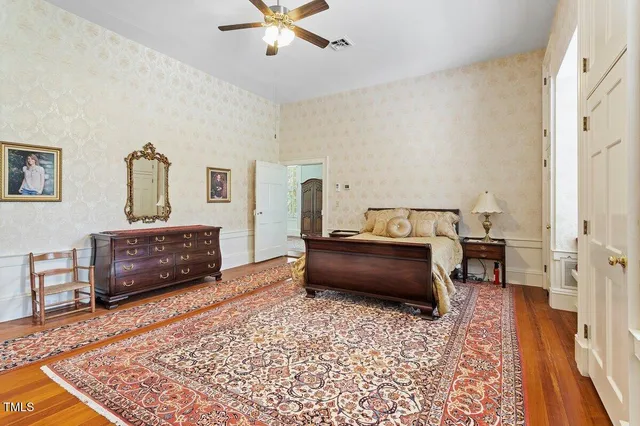 a bedroom with a bed and a chandelier fan