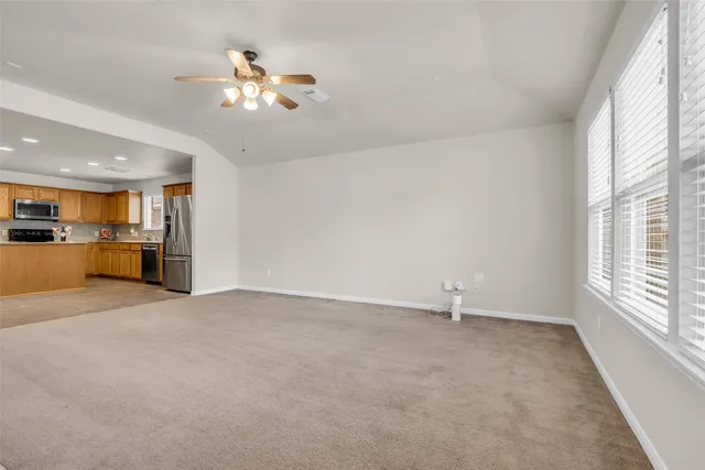 an empty room with a window and a fan
