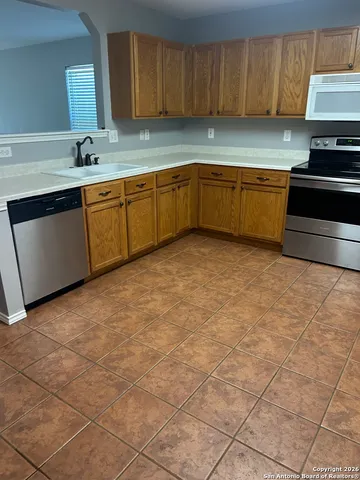 a kitchen with stainless steel appliances a sink stove and cabinets