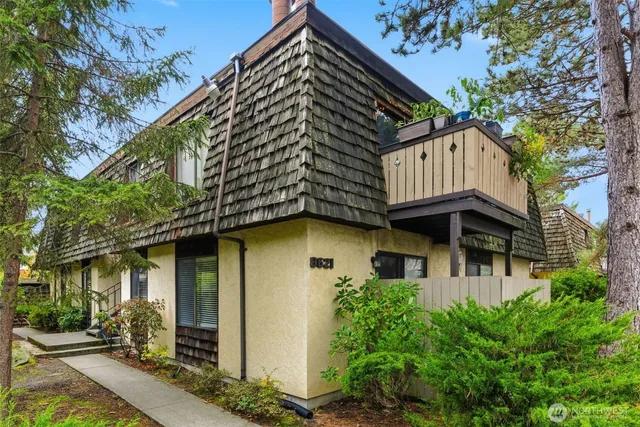 a view of a house with a large windows and flower plants