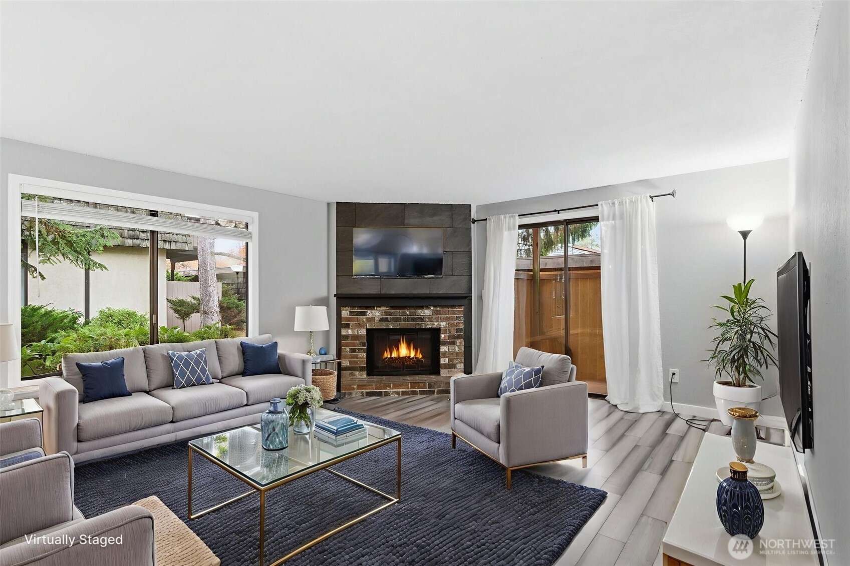 a living room with furniture a flat screen tv and a fireplace