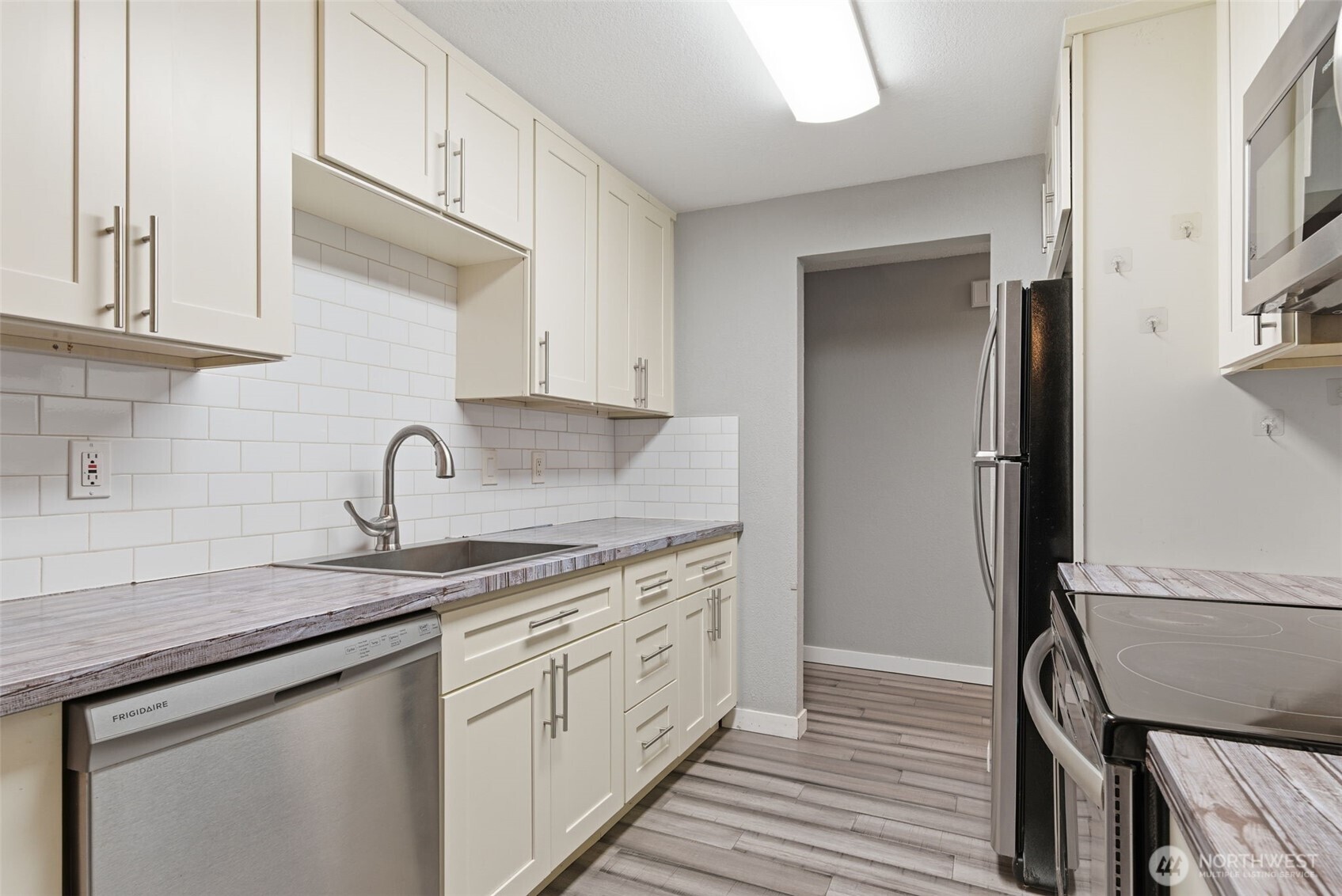 8621 25th Avenue Southwest, Unit B Seattle, WA 98106 - Photo 11 of 33 a kitchen with stainless steel appliances granite countertop white cabinets and sink