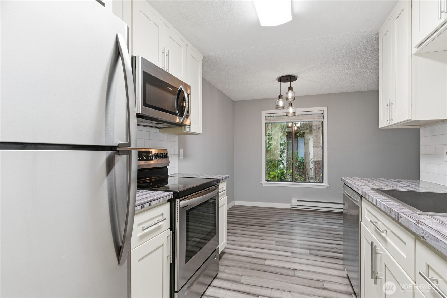8621 25th Avenue Southwest, Unit B Seattle, WA 98106 - Photo 12 of 33 a kitchen with stainless steel appliances granite countertop a sink stove and refrigerator
