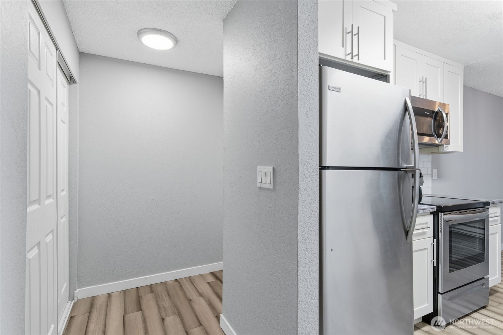 8621 25th Avenue Southwest, Unit B Seattle, WA 98106 - Photo 13 of 33 a view of a kitchen with refrigerator and white cabinets