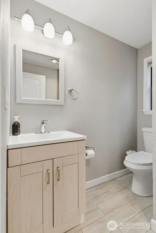 a bathroom with a sink a toilet and mirror