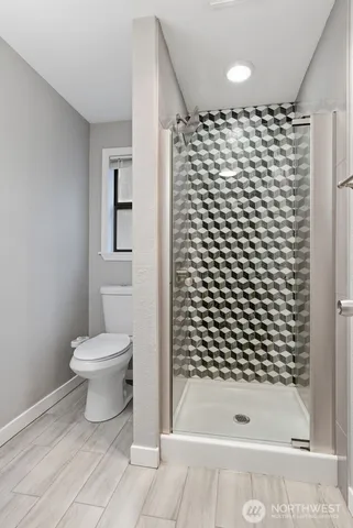 a bathroom with a toilet and a shower