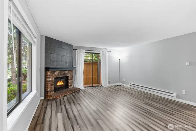 a view of an empty room with a fireplace and a window