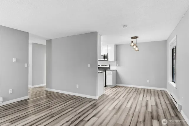 a view of empty room with wooden floor