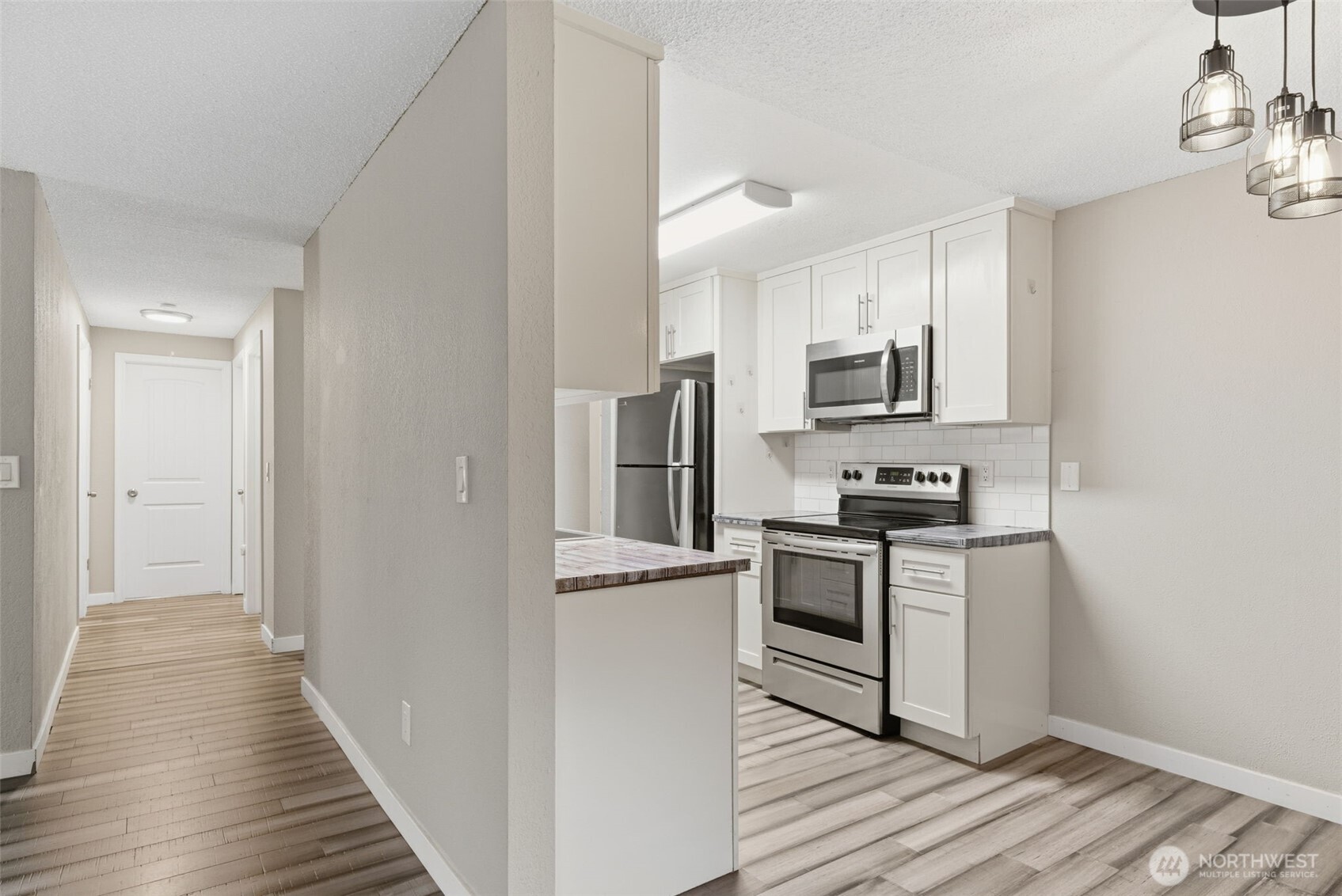 8621 25th Avenue Southwest, Unit B Seattle, WA 98106 - Photo 9 of 33 a kitchen with cabinets stainless steel appliances and wooden floor