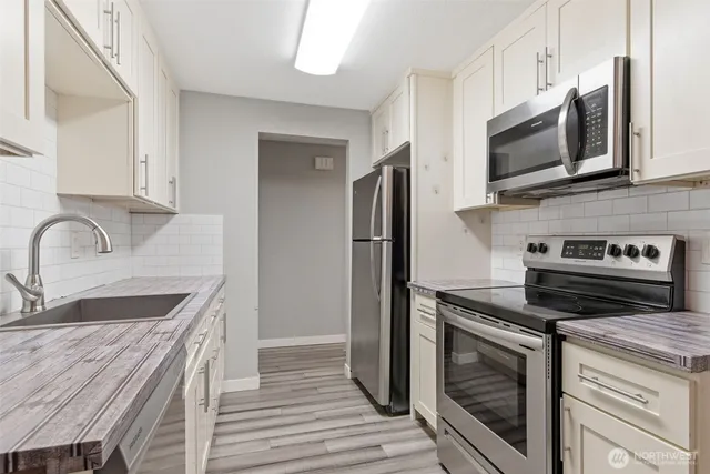 a kitchen with stainless steel appliances granite countertop a stove microwave and refrigerator