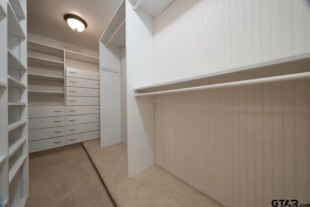 a view of walk in closet with empty racks