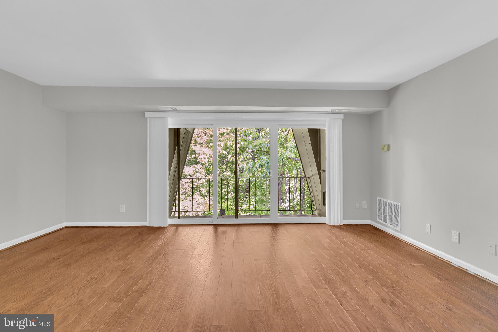 11620 Vantage Hill Road, Unit 22B Reston, VA 20190 - Photo 7 of 24 a view of an empty room with wooden floor and a window