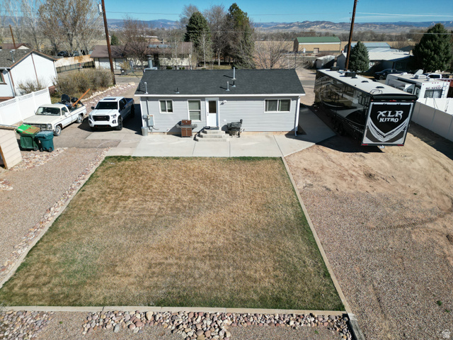 1852 East 3500th Street South Vernal, UT 84078 - Photo 38 of 46 Rear view of house featuring driveway, a mountain view, a residential view, and a patio