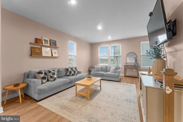 a living room with furniture and a view of kitchen