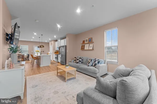 a kitchen with stainless steel appliances kitchen island granite countertop a stove a sink a dining table and chairs with wooden floor