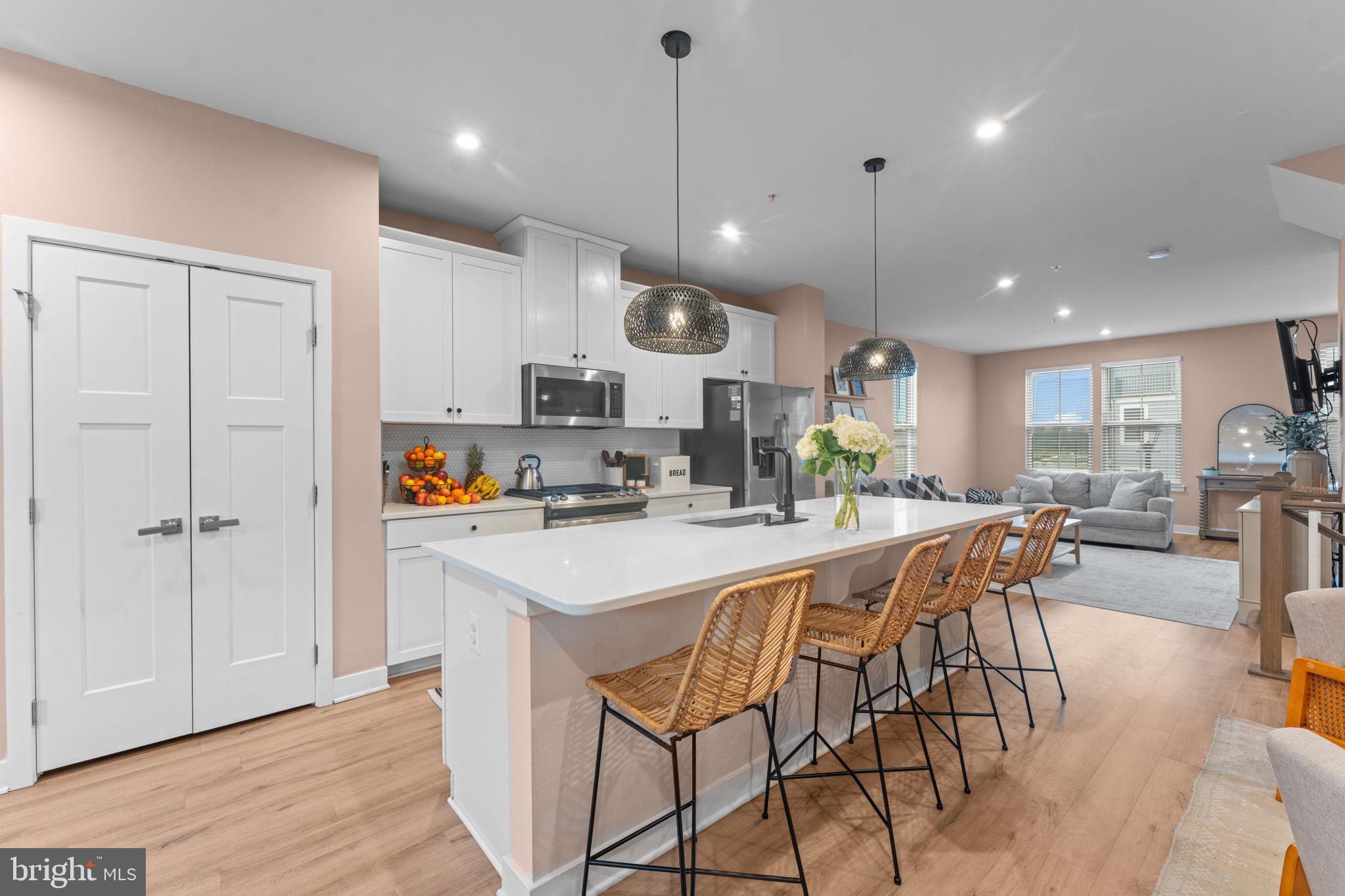 160 Lyons Creek Drive Laurel, MD 20708 - Photo 24 of 88 a kitchen with stainless steel appliances kitchen island granite countertop a stove a sink a dining table and chairs with wooden floor