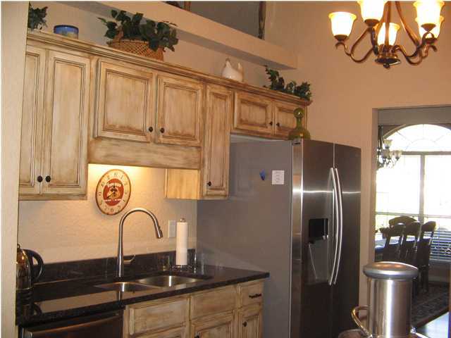 174 East Shipwreck Road Santa Rosa Beach, FL 32459 - Photo 5 of 11 a kitchen with stainless steel appliances granite countertop a refrigerator a stove and a sink with wooden floor