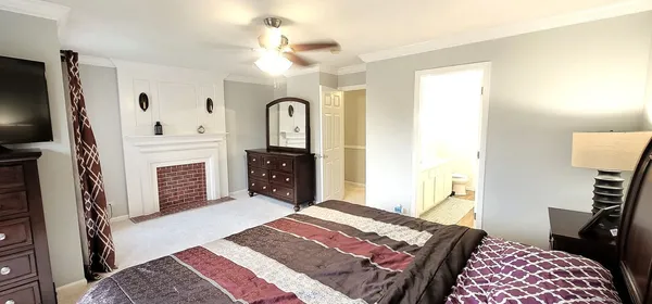 a bedroom with a bed dresser and a flat tv screen