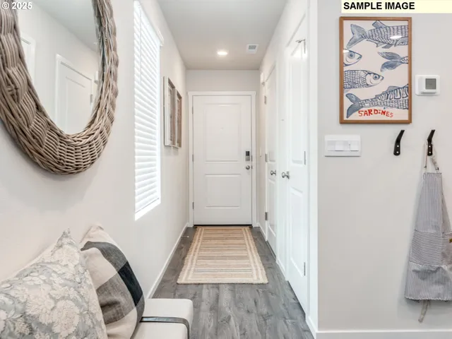 a view of a hallway with wooden floor and a bathroom