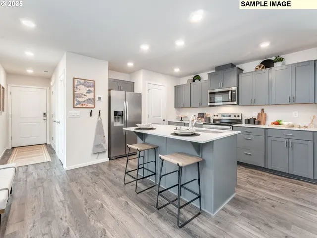 a kitchen with kitchen island wooden floors appliances and center island