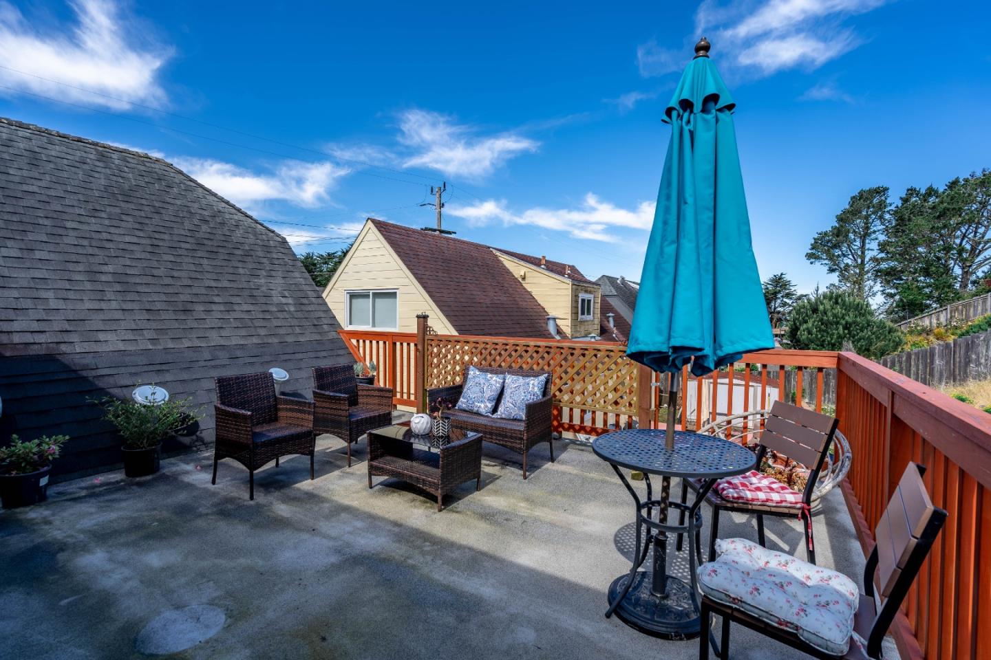 348 Heathcliff Drive Pacifica, CA 94044 - Photo 30 of 37 a view of a patio with table and chairs with wooden floor and fence
