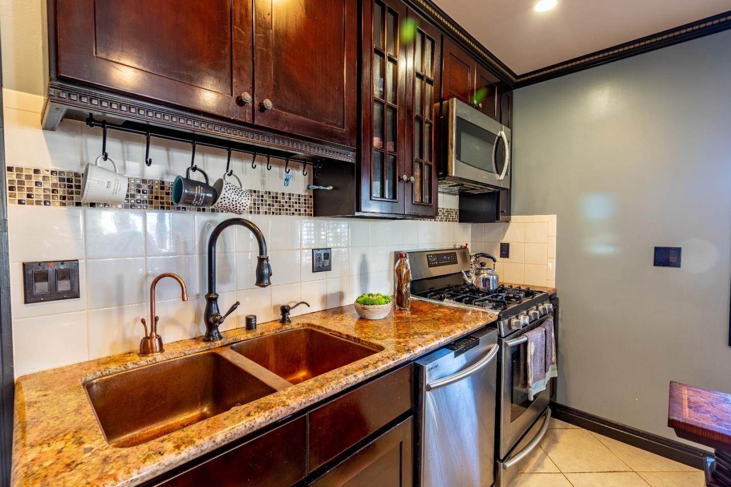 348 Heathcliff Drive Pacifica, CA 94044 - Photo 8 of 37 a kitchen with stainless steel appliances a sink a stove and a sink with wooden cabinets