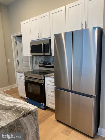 a kitchen with stainless steel appliances a refrigerator sink and microwave