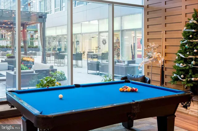 a living room with furniture a rug and a floor to ceiling window