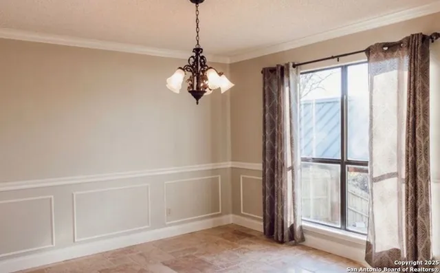 a view of a livingroom with a chandelier fan and windows