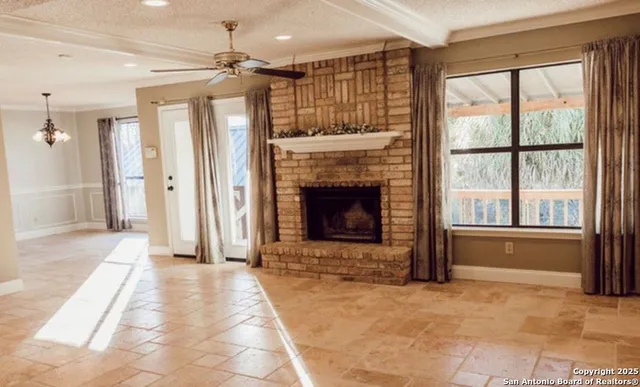 a view of an empty room with a fireplace and a window