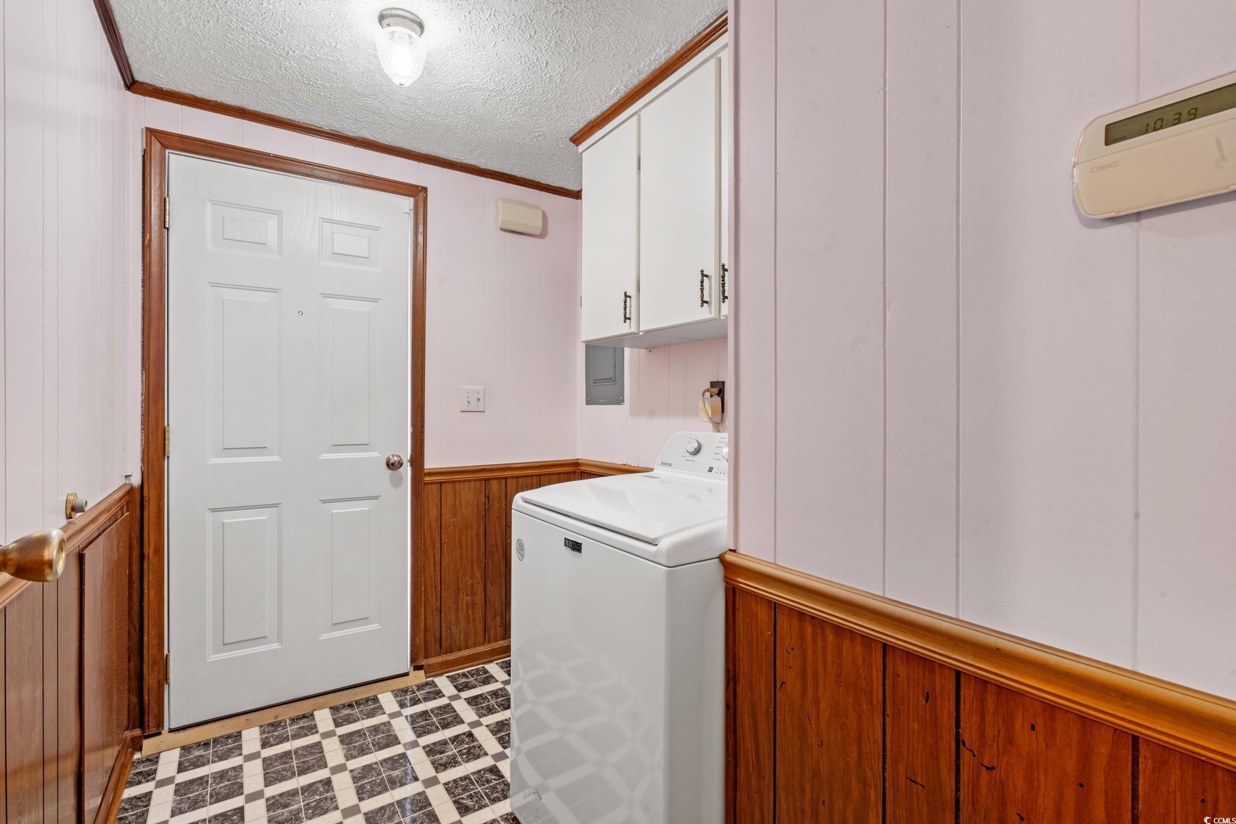 4422 Grady Road Mullins, SC 29574 - Photo 15 of 28 Laundry room featuring washer / dryer, crown molding, wooden walls, a textured ceiling, and a wainscoted wall