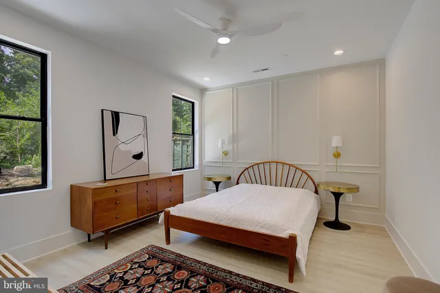 a bedroom with a bed a window and painting on the wall