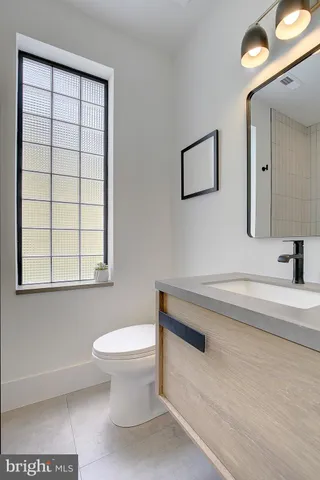 a bathroom with a toilet a sink and a window