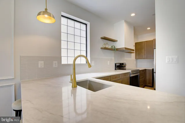 a kitchen with stainless steel appliances granite countertop a sink a stove and a refrigerator