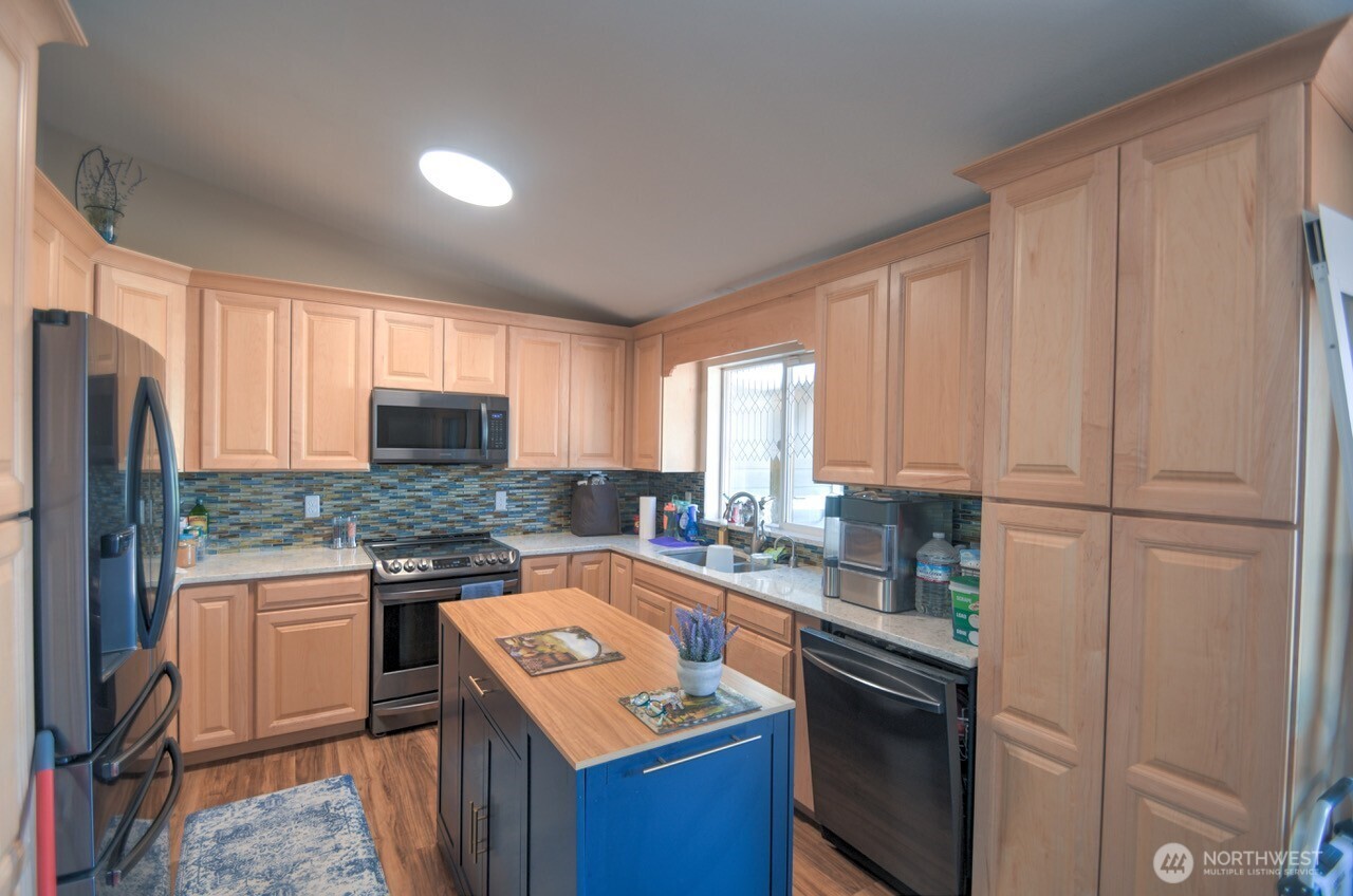 5922 184th Lane Southwest Rochester, WA 98579 - Photo 4 of 34 a kitchen with stainless steel appliances granite countertop a sink stove refrigerator and cabinets